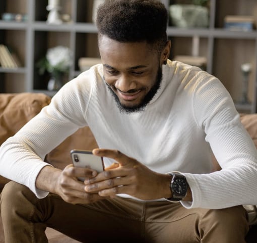 A man smiling while going through his mobile phone